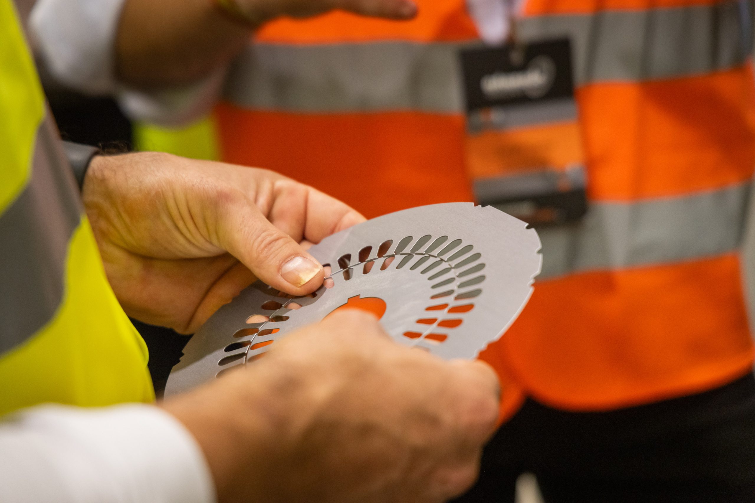 Manos sujetando una pieza de acero terminada